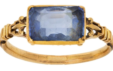 An early 19th century gold and sapphire ring, centering on a rectangular mixed-cut sapphire to open work shoulders, applied with fleur-de-lis motifs ring size J