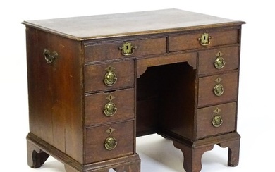 An early / mid 18thC oak kneehole desk with a moulded top ab...