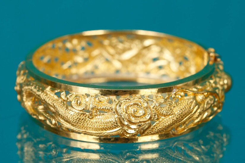 Bracelet En or jaune contrôlé 18 K (750‰) à décor ajouré d’un dragon et d’un phénix poursuivant la perle sacrée D. 5,5 cm Poids 30,5 gMarqué 22K