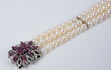 Bracelet de trois rangs de perles de culture blanches. Il est agrementé d'un important fermoir...