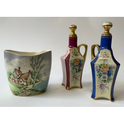 Lotto composto da una coppia di bottiglie in porcellana policroma a decoro floreale, e un vaso in porcellana con decoro...