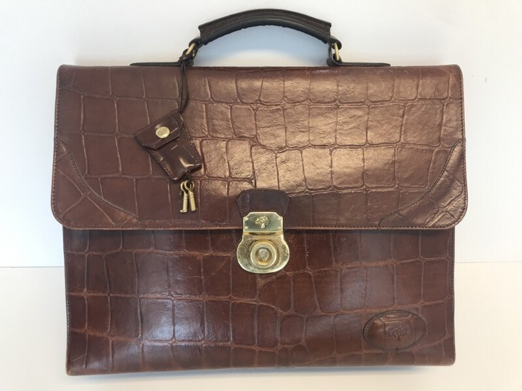 Mulberry: A bag made of brown leather with gold toned hardware, short handle, three compartments with one inside zipped pocket.