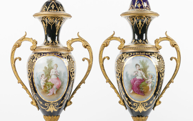 Paar eivormige twee-orige en gedekte vazen op voet. Deels goudgehoogd 'Sèvres'-porselein. Beschilderd vooraan met nimf e