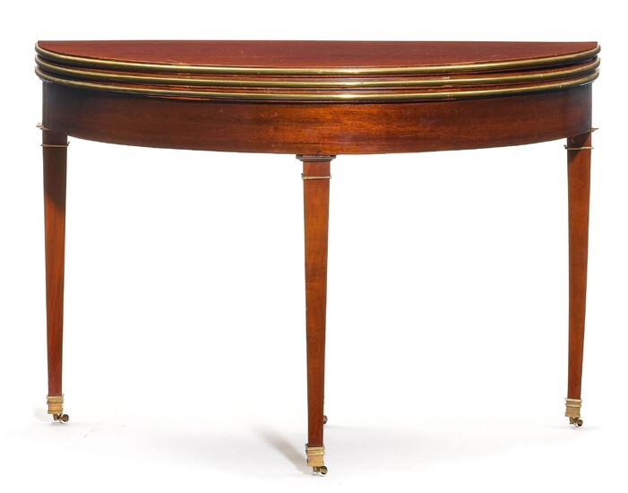TABLE DE JEU DEMILUNERestauration, France, 19e siècle.Acajou. Vantail semi-circulaire en deux parties, articulé, avec bordure...