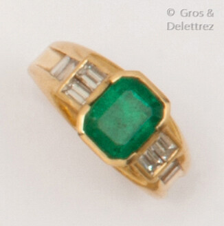 Yellow gold ring set with a rectangular emerald set with baguette diamonds. Finger size: 54. Rough: 6.1g.