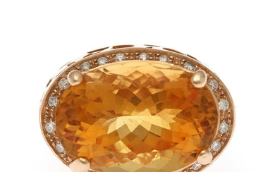 A citrine and diamond ring set with an oval-cut citrine encircled by numerous brilliant-cut diamonds, mounted in 18k gold. Size 54.