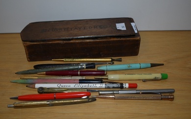 A 20th Century wooden sliding pencil box, measuring 21cm long, with vintage pens including a