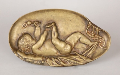 A BRONZE RELIEF IN THE FORM OF A BABY HOLDING A RATTLE