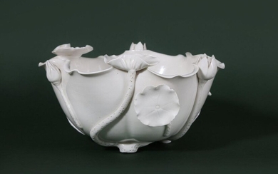 A CHINESE BLANC-DE-CHINE 'LOTUS LEAF' WASHER. Qing Dynasty. Modelled in the shape of a large upturned lotus leaf with attendant buds and leaves at the undulating rim, all resting on three short feet formed as stems, 22cm across. 清 德化窯荷葉形筆洗