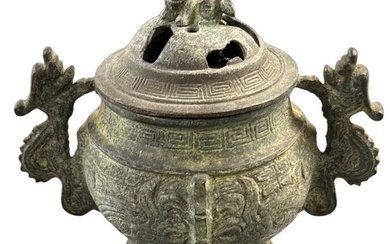 A Chinese archaic style lidded bronze censer, with twin handles...