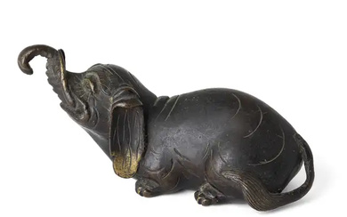 A Chinese bronze 'elephant' paper weight Ming dynasty The recumbent beast raising...