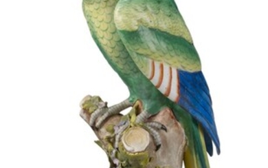 A Continental porcelain parrot, late 19th century, perched on a floral encrusted tree stump, bearing gilt anchor mark to reverse, incised 10 to underside, 44cm high