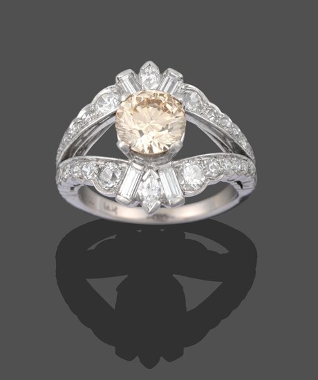A Diamond Cluster Ring, the central fancy light brown round brilliant cut diamond in a white...