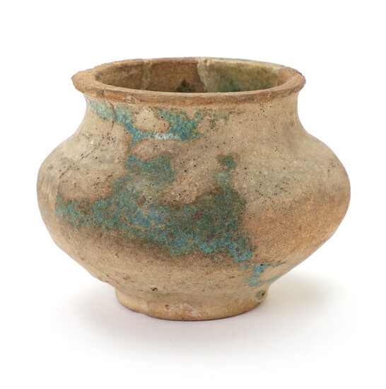 A Kashan (partly) blue-glazed moulded pottery jar, Persia, 13th century. H. 11.5 cm.