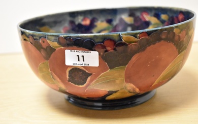 A Moorcroft Pottery fruit bowl, having tube lined grape and pomegranate design on cobalt blue