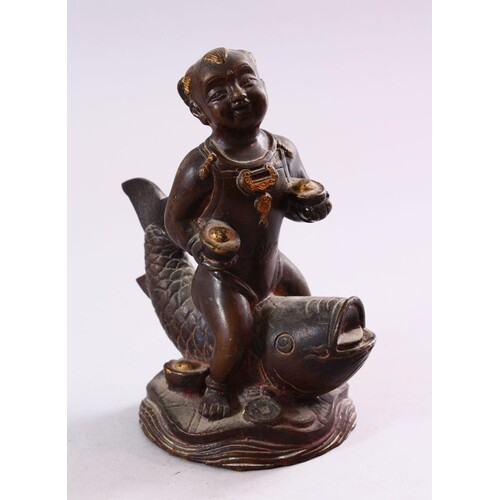 A SMALL CHINESE BRONZE FIGURE OF A BOY SEATED UPON A CARP, 1...