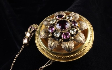A Victorian Brooch set with a ruby surrounded by oval amethysts and diamonds fitted with a safety ch