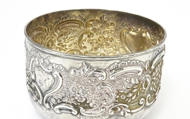 A Victorian silver bowl with embossed floral and scroll deco...
