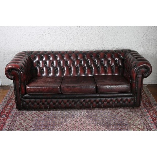 A WINE HIDE UPHOLSTERED LIBRARY SETTEE with button upholster...
