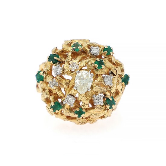 A diamond and emerald ring set with a pear-shaped diamond encircled by numerous brilliant-cut diamonds and baguette-cut emeralds, mounted in 18k gold. Size 53.