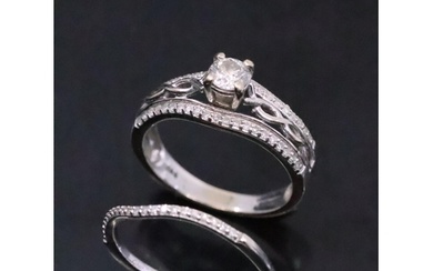 A diamond solitaire ring set with diamond shoulders in a cel...