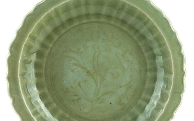 A large Chinese Longquan celadon-glazed charger, Ming dynasty, 15th century, incised to the central reserve with lotus flowers, the cavetto with ribbed decoration, 37.5cm diameter 明十五世紀 龍泉青釉花口大盤