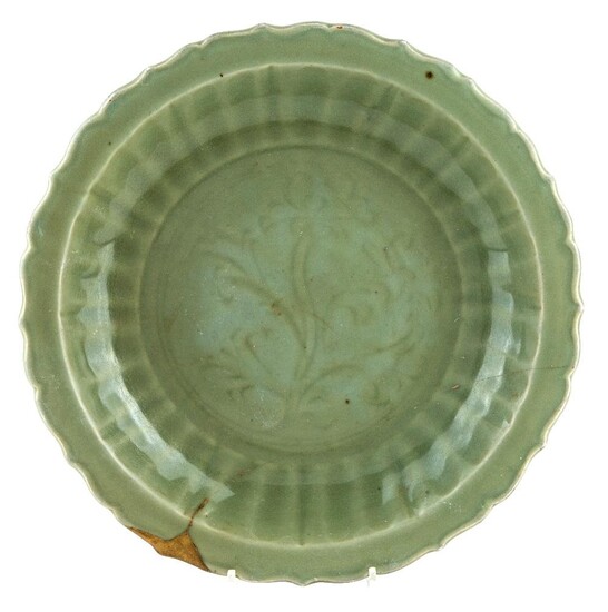 A large Chinese Longquan celadon-glazed charger, Ming dynasty, 15th century, incised to the central reserve with lotus flowers, the cavetto with ribbed decoration, 37.5cm diameter 明十五世紀 龍泉青釉花口大盤