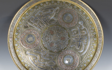 A large Middle Eastern Mamluk Revival brass circular tray, overlaid in silver and copper with foliag