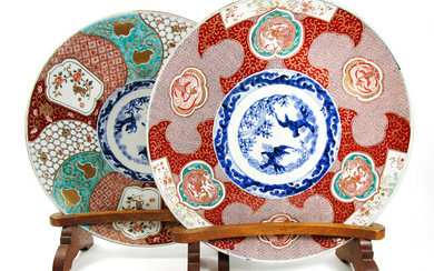 A matched pair of Imari chargers on wooden stands