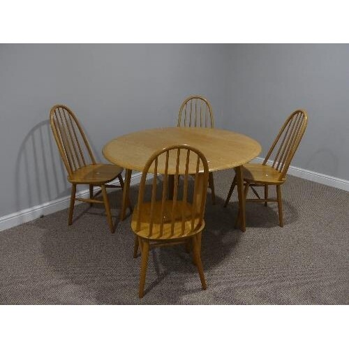 A mid 20thC Ercol style drop leaf oval Dining Table, the top...