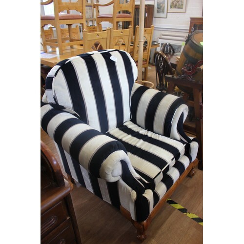 A modern upholstered easy chair, covered in a striped patter...