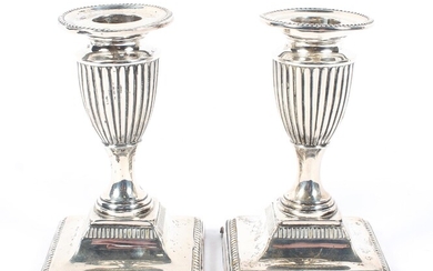 A pair of Edwardian squat silver candlesticks of urn form