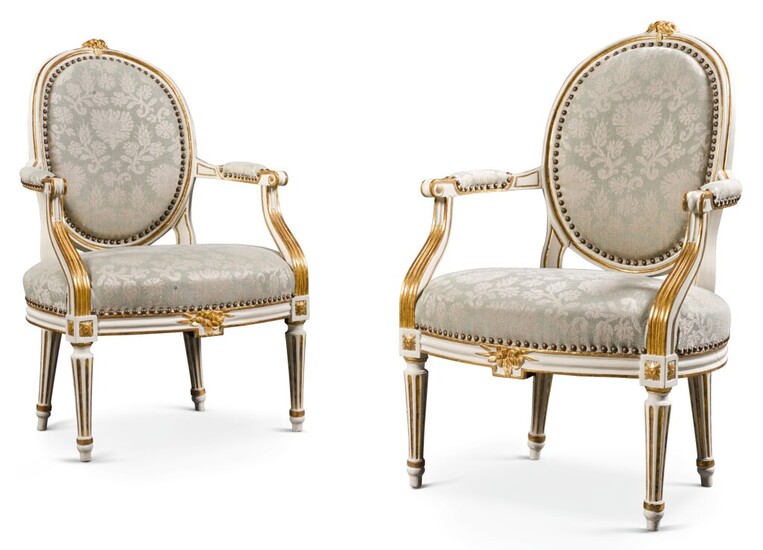 A pair of Louis XVI style parcel-gilt painted open armchairs