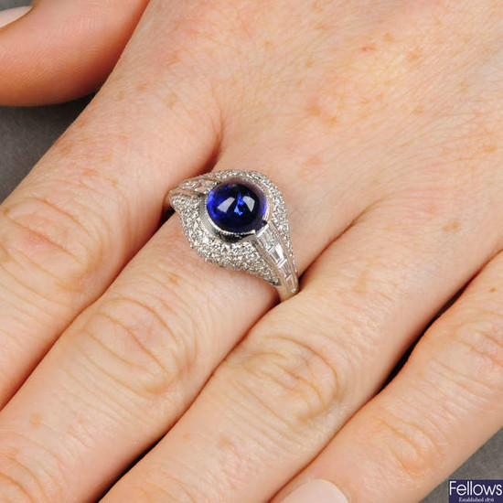 A sapphire cabochon and brilliant and tapered baguette-cut diamond dress ring.