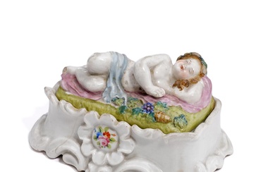 A small early 19th century porcelain inkwell, lid moulded with a sleeping...
