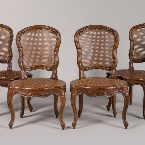 A suite of four walnut chairs, moulded and carved with...