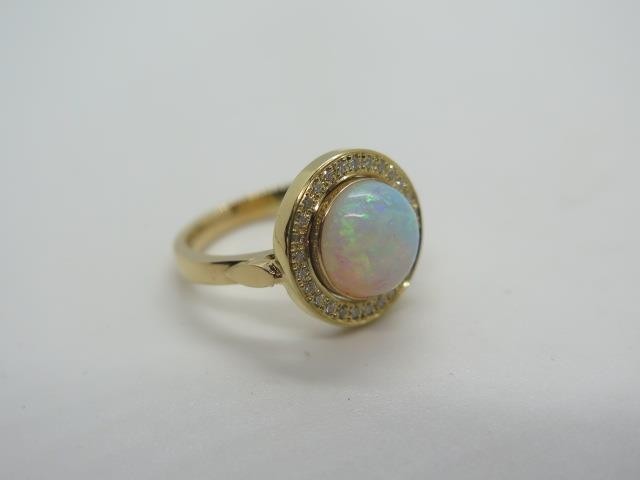 A yellow gold opal and diamond ring, tests to 18ct ring size...