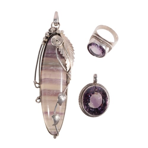 AN AMETHYST AND SILVER PENDANT the oval-cut amethyst, set in...