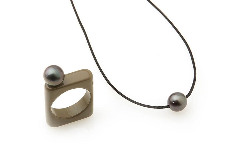 Adjustable black cord necklace, decorated with a Tahitian pearl; A square khaki bakelite ring decorated with a Tahitian pearl is attached to this necklace. TDD: 57