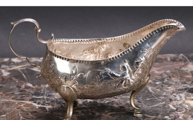 An 18th century Irish silver sauce boat, chased with figures...