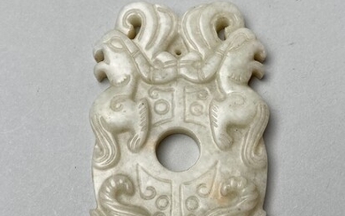 CHINE, XXe. Pendentif en jade à décor de masque de taotie archaïsant. 8,3 x 5...
