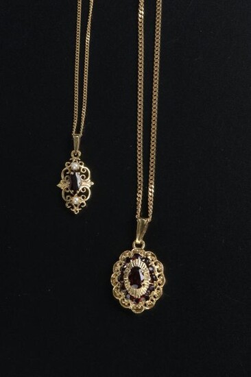 18k yellow gold chain link necklace holding an 18k yellow gold pendant set with a faceted oval almandine garnet in a setting of twelve round almandine garnets.