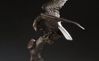 JAPON Sculpture en bronze patiné représentant un faucon perché sur un tronc d'arbre, les yeux...