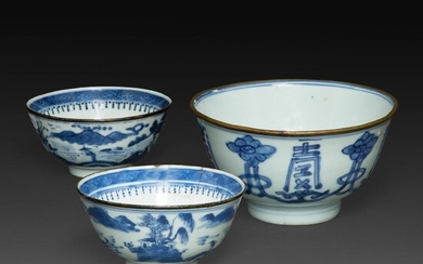 SUITE DE TROIS BOLS en porcelaine bleu-blanc dite "de Hué", deux à décor d'une scène paysagée, vue d'architectures et cité lacu...