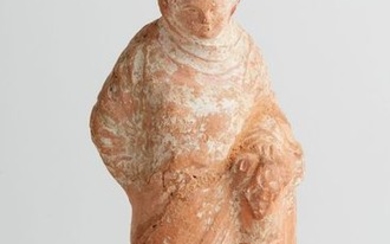 Terracotta statuette called "Tanagra". She is dressed in...