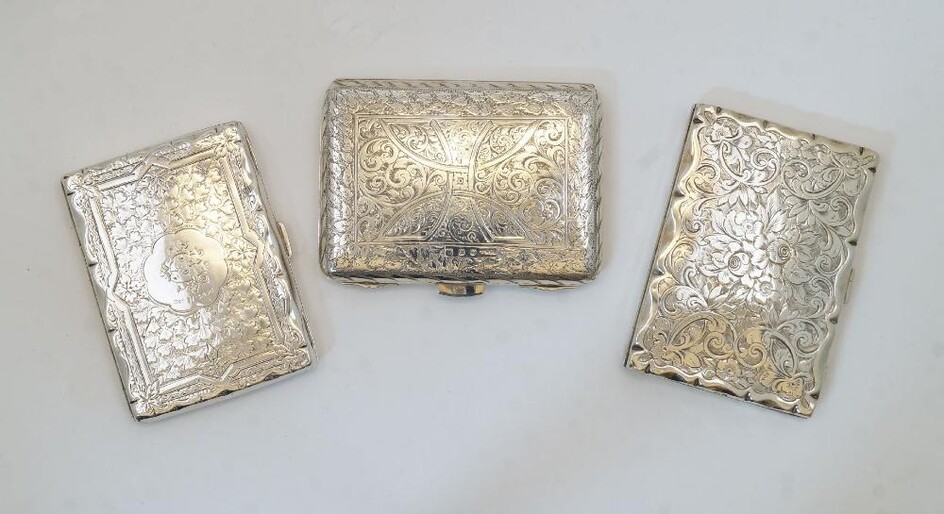 Three silver card cases, comprising: a Victorian example with chased leaf and scrolling foliate decoration, Birmingham, 1886, H J Cooper & Co Ltd, with leather interior and propelling pencil, 10.2cm high, 8cm wide; another Victorian example with...