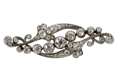 A diamond brooch of scrolling form, the central line of