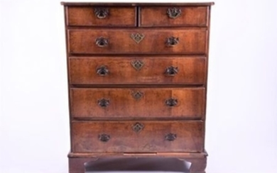 A Georgian walnut chest with two short over three graduated long drawers, pierced brass mounts and swing handles, on bracket...