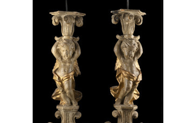 A pair of 18th-century carved and partially gilded candle holders, on carved bases (h. cm 49)
