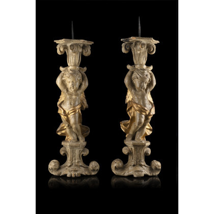 A pair of 18th-century carved and partially gilded candle holders, on carved bases (h. cm 49)